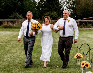 Bride and her brothers with sunflower bouquet