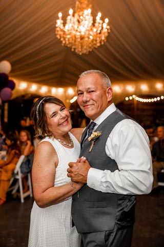 Wedding first dance bride and groom in reception tent with chandelier