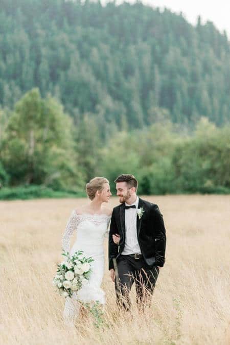 Bride and groom walking in field at Mount Peak Farm