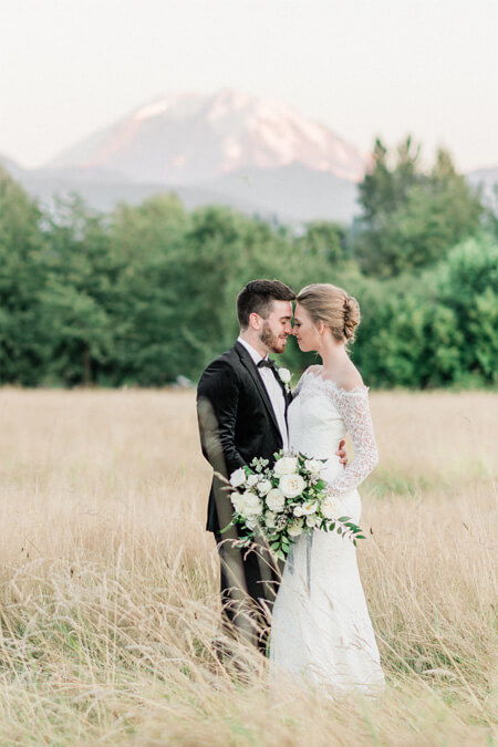 Bride and groom in hayfield with Mount Rainier view at Mount Peak Farm Wedding and Event Venue