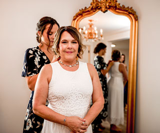 Bride and daughter get dressed in from of gold mirror at Mount Peak Farm