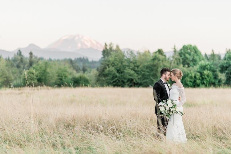 French Countryside Wedding Inspiration Bride and groom in hayfield with Mount Rainier view.