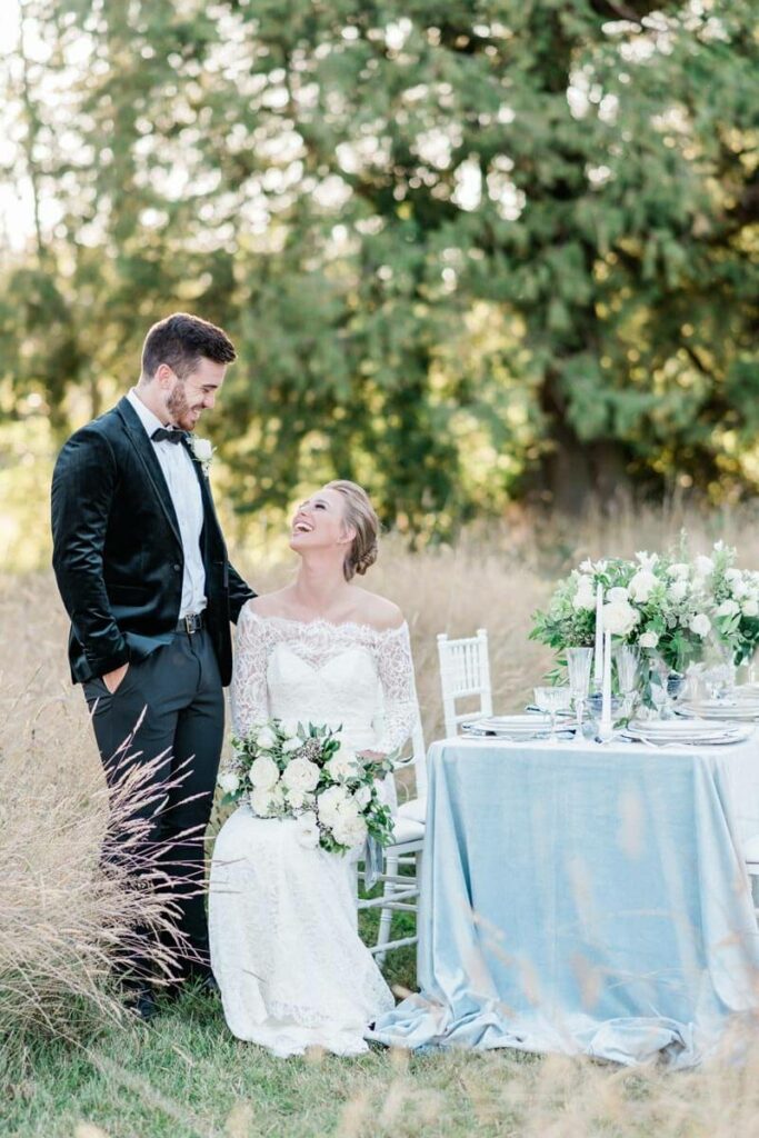 French Countryside Wedding Inspiration bride and groom at reception table in field
