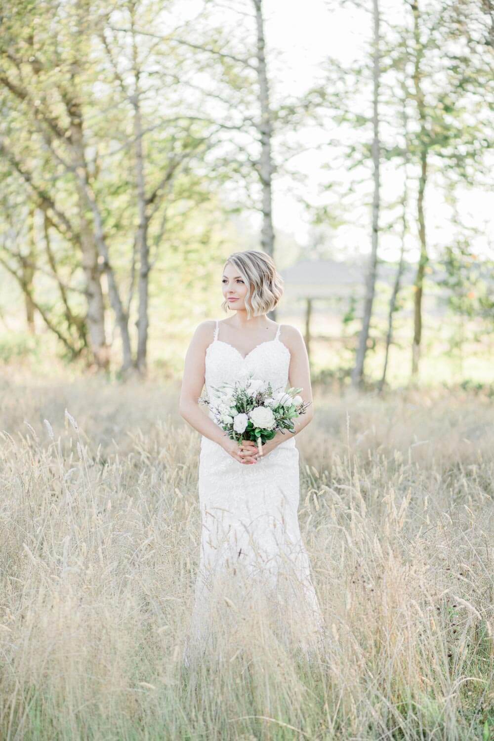 Bride in hayfield with bouquet at Mount Peak Farm