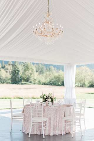 Romantic blush wedding table under chandeliers