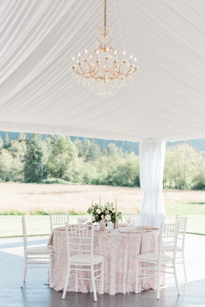 Romantic blush wedding table under chandeliers at Mount Peak Farm