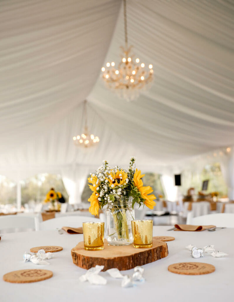 Reception tent with sunflowers and chandeliers