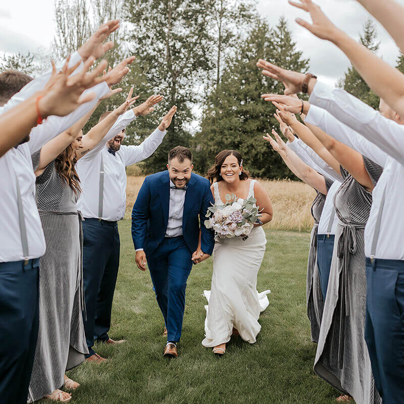 Bride and Groom in tunnel with wedding party