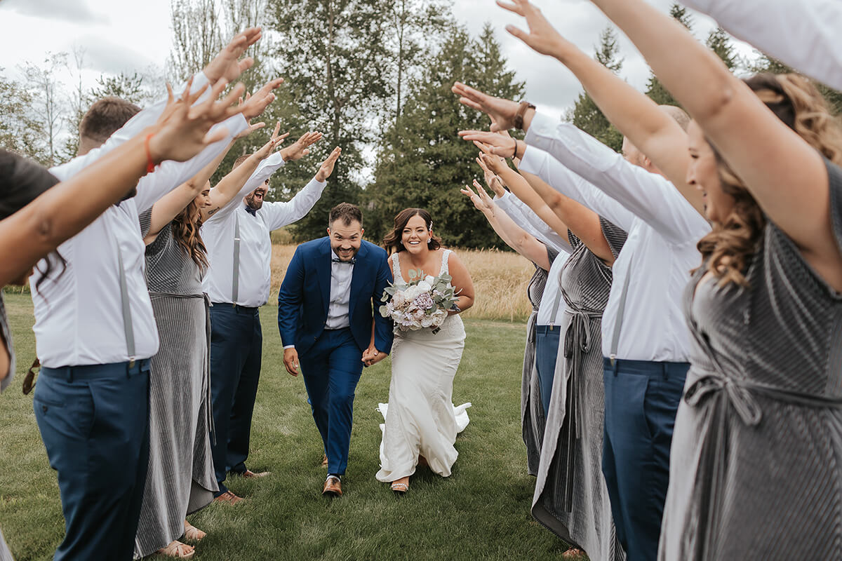 Bride and groom in tunnel of friends