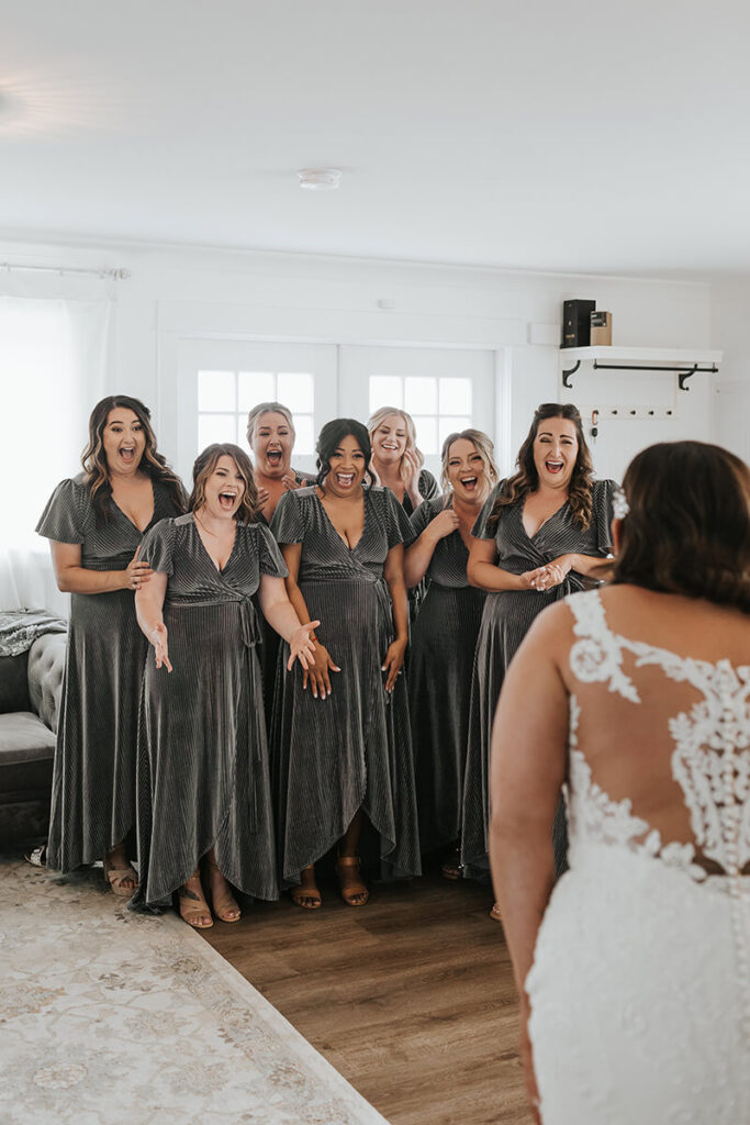 Bridesmaids smiling at bride