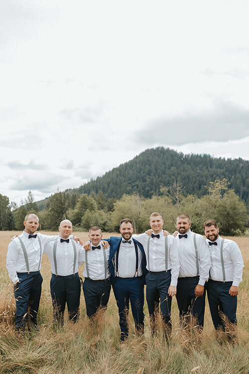 Groom and groomsmen in hayfield