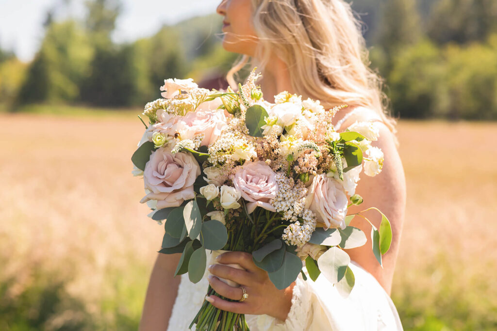 Bride holding bouquet in field at Mount Peak Farm