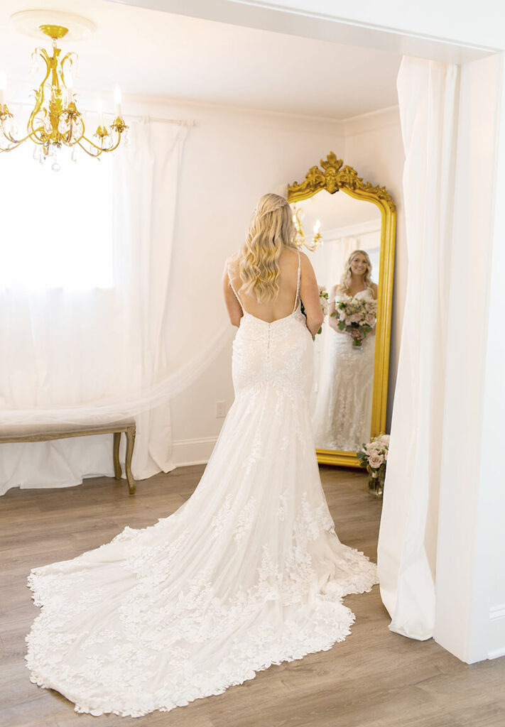 Bride looking in gold mirror in bridal cottage at Mount Peak Farm