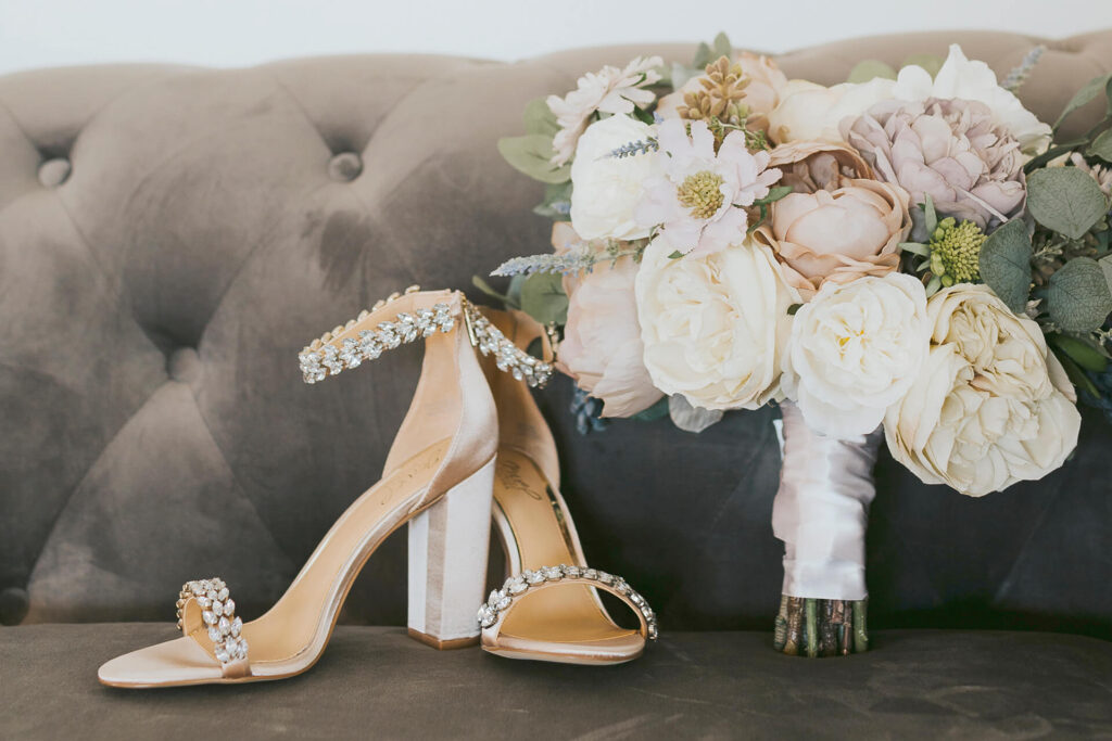 Glam shoes and bouquet on velvet sofa