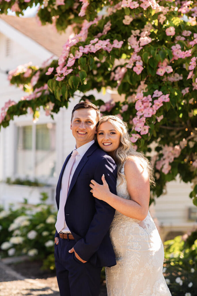 Bride and groom with blush flowered tree at Mount Peak Farm