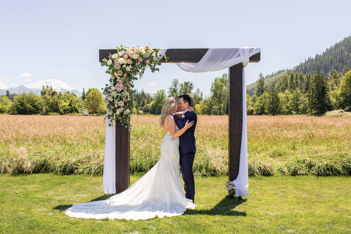 Beautiful Blush wedding couple and arbor at Mount Peak Farm