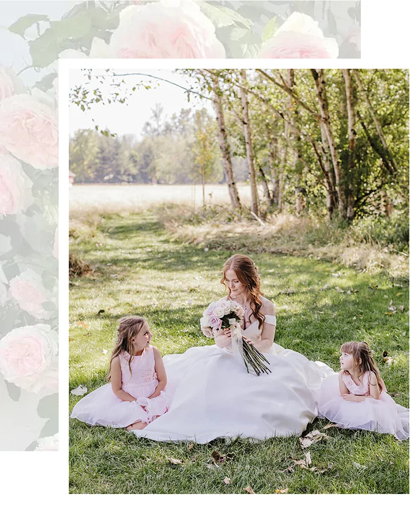Bride with flowergirls sitting in grass at Mount Peak Farm wedding venue