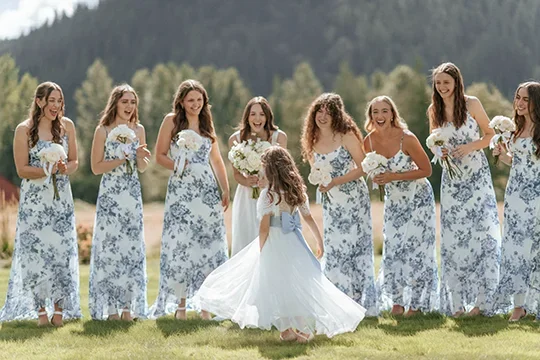 Flowergirl twirls with Bride and bridesmaids in sunshine at Mount Peak Farm wedding venue