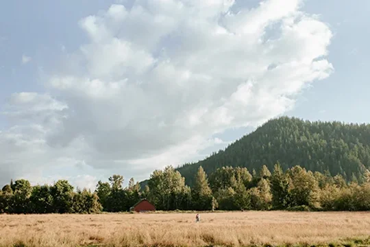 Washington wedding venue - Mount Peak Farm. Couple in hayfield with open skies